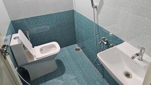 A bathroom with a toilet, sink, and shower. - Blumint 303 (Bengaluru)