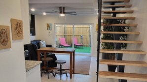 Een modern interieur met een trap, een eethoek en uitzicht op het omliggende landschap.