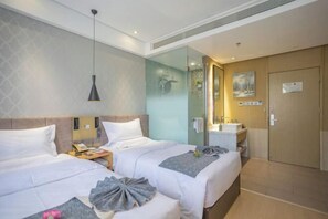 A hotel room with two beds, a bedside table with a lamp, a bathroom with a mirror, and a door with a sign. - Beijing Huashang Hotel (Sanyuanqiao Yansha Embassy Area Branch) (Beijing)