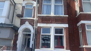 A two-story red brick building with a white-framed entrance and a sign that reads "Welcome to The Avon." - The AVON Hotel (Blackpool)
