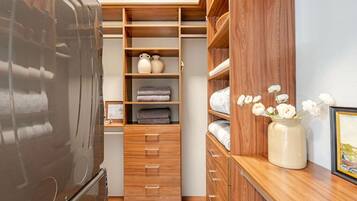 Un vestidor con estanterías de madera, cajones y un espejo.