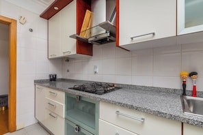 Suite, vista a la ciudad | Cocina privada | Refrigerador con congelador, microondas, horno y parrilla de estufa 