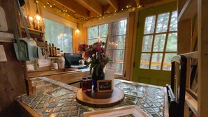 A cozy room with a stone city-themed table, a welcome sign, and a framed picture on the table. - Streamside treehouse in the Vermont forest with access to sauna (Hardwick)