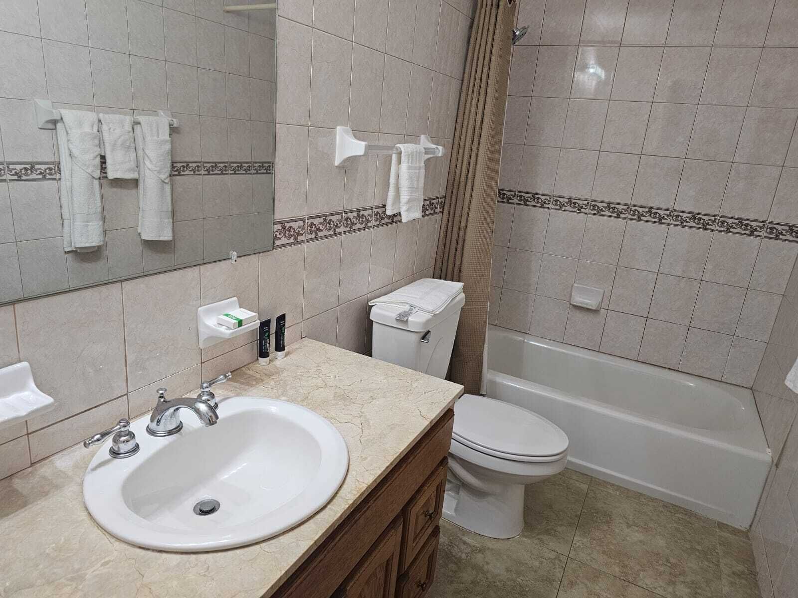 A bathroom with a sink, toilet, and bathtub.