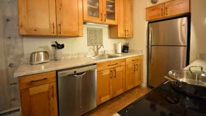 A kitchen with wooden cabinets, stainless steel appliances, and a dishwasher. - Excellent Location on Main Street, Breckenridge!  2 Bedroom/2 Bath (Breckenridge)