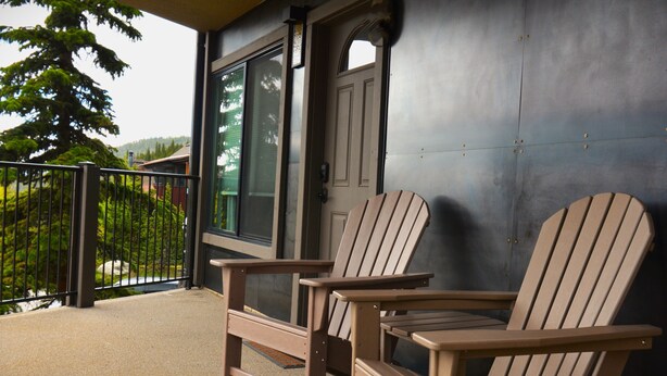 Two Adirondack chairs on a balcony with a view of a house and a tree. - Excellent Location on Main Street, Breckenridge!  2 Bedroom/2 Bath (Breckenridge)