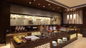 A buffet setup with various food items and utensils. - Country Inn Premier Amritsar (Amritsar)