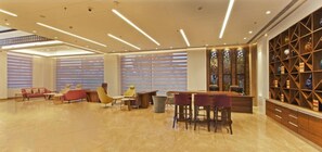 A spacious lobby with a bar area, seating arrangements, and a decorative wall with shelves. - Country Inn Premier Amritsar (Amritsar)