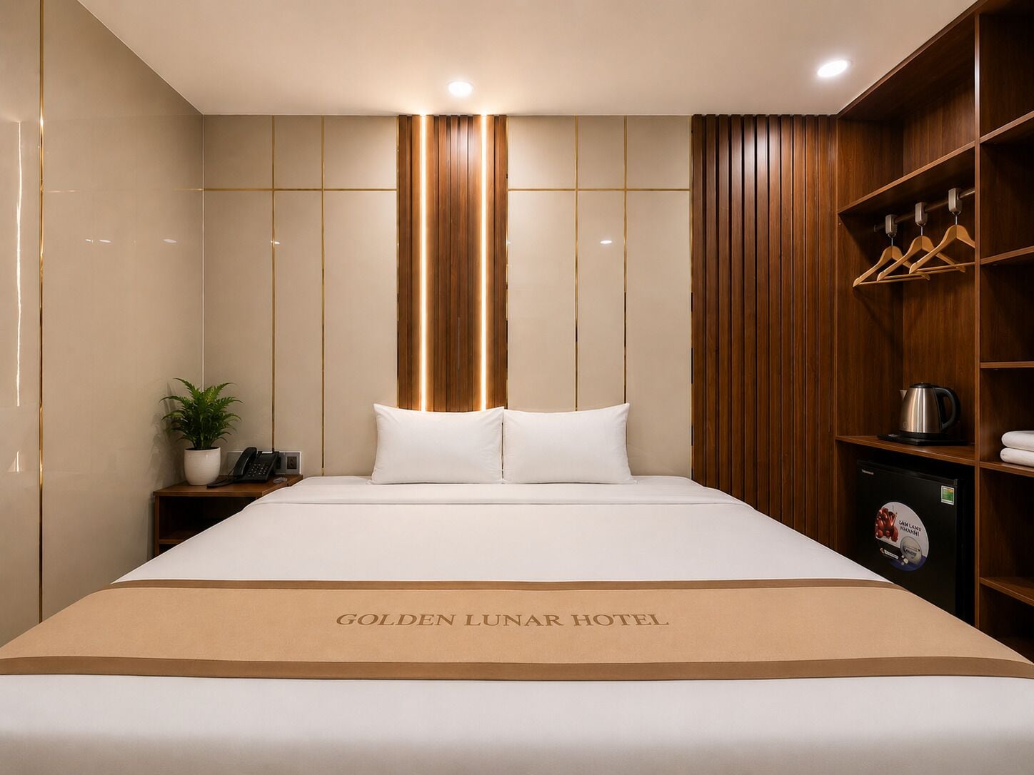 Une chambre d’hôtel avec un lit, une table de chevet avec un téléphone et une plante, une armoire en bois et une pancarte sur le lit indiquant « HÔTEL GOLDEN LUNAR ».