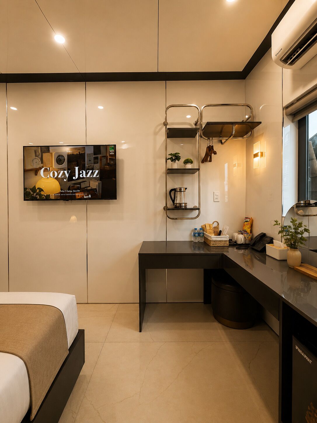 Quarto de hotel moderno com cama, escrivaninha, televisão, prateleira com plantas e cafeteira.
