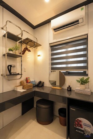 A modern bathroom with a black countertop, a round mirror, a towel rack, a hanging showerhead, and a window with blinds. - Golden Lunar (Ho Chi Minh City)