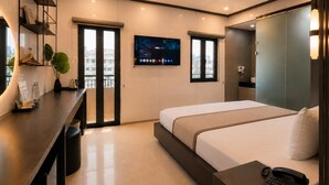 A modern hotel room with a bed, bedside table, a desk with a chair, a TV mounted on the wall, and a window with a view of the city. - Golden Lunar (Ho Chi Minh City)