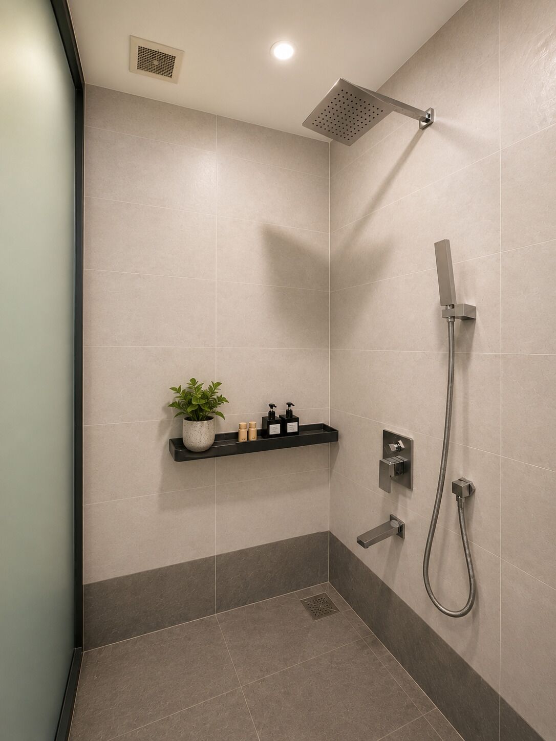 Een moderne badkamer met een douche, een plankje met toiletartikelen en een potplant.
