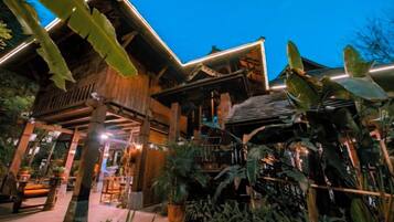 A traditional wooden building with a covered entrance and potted plants.