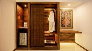 A wooden wardrobe with a sliding door, a small refrigerator, and a framed artwork on the wall. - Jinghong Manying Dai Tai Courtyard Villa (Jinghong)