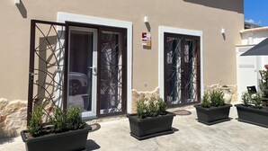 A building with two sliding glass doors, a signboard, and potted plants in the foreground. - Domus Joannina B&B (Pompei)