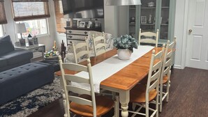 A dining area with a wooden table and chairs, a hanging pendant light, and a sign above the table reading "JERSEY SHORE". - Lagoon Life, Beach Please! (Stafford Township)