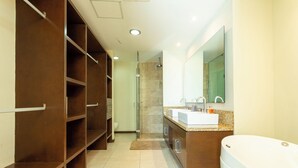 Un baño moderno con ducha a ras de suelo, un espejo grande y un tocador con lavabo.