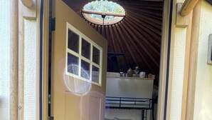 Ein Durchgang zu einem Raum mit einem Etagenbett, einem kleinen Fenster und einem Deckenventilator.