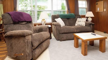A living room with two sofas, a coffee table, and a lamp.