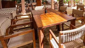 An outdoor patio area with wooden tables and wicker chairs, surrounded by a pergola and palm trees. - Resort-Style Loft in AfloraTulum (Tulum)