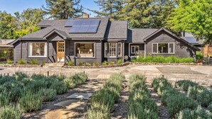 Ein modernes Haus mit Solaranlage, einem Kiesweg und einem gepflegten Garten.