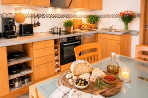 A kitchen with wooden cabinets, a coffee maker, a toaster, and a variety of food items on the counter.