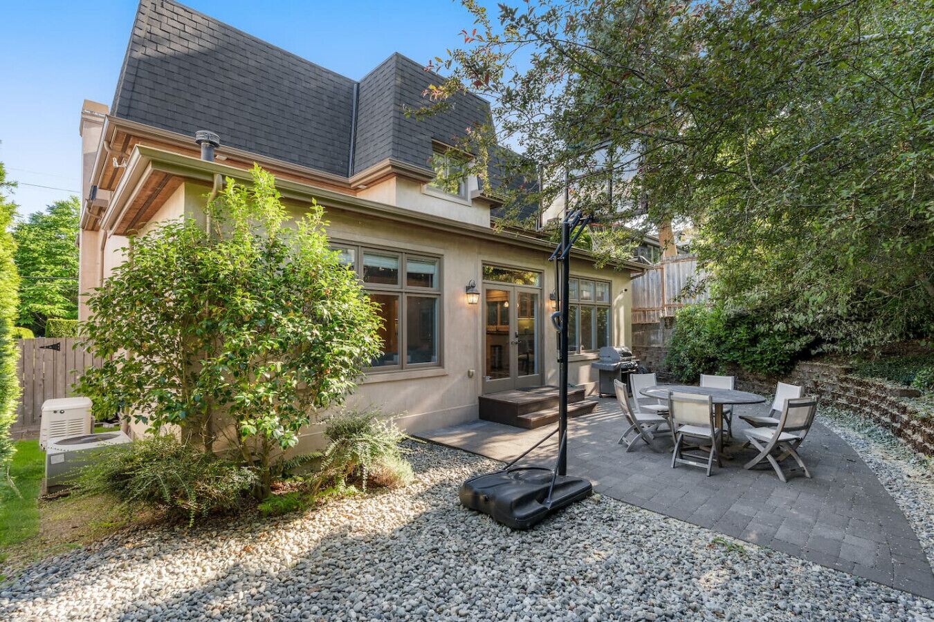 Une maison avec un patio, du mobilier d’extérieur et un barbecue.