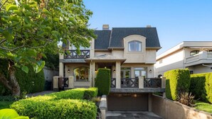 Une maison  à deux étages dotée d’un porche avant couvert, d’un garage et d’un jardin bien entretenu.