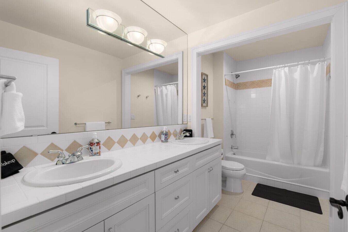 A modern bathroom with a large mirror, a sink, a toilet, and a shower.