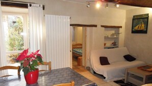 Una habitación acogedora con una mesa de comedor, sillas, un sofá y una cama.