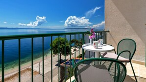 A balcony with a view of the sea, a table with chairs, and a vase of flowers. - Villa Paško - Double room with Balcony and Sea View (Podgora)