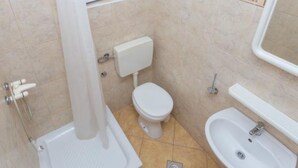 Un baño con inodoro, lavabo y ducha.