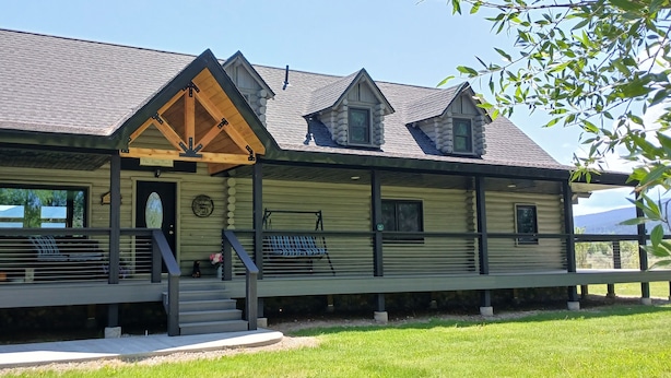 A log cabin with a porch, a bench, and a small staircase leading to the entrance.
