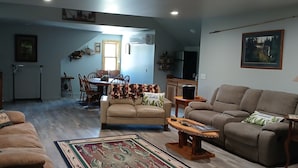 A living room with two sofas, a coffee table, and a dining area with chairs and a table.