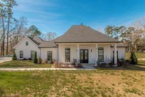 A two-story house with a front porch, a garage, and a well-maintained lawn.