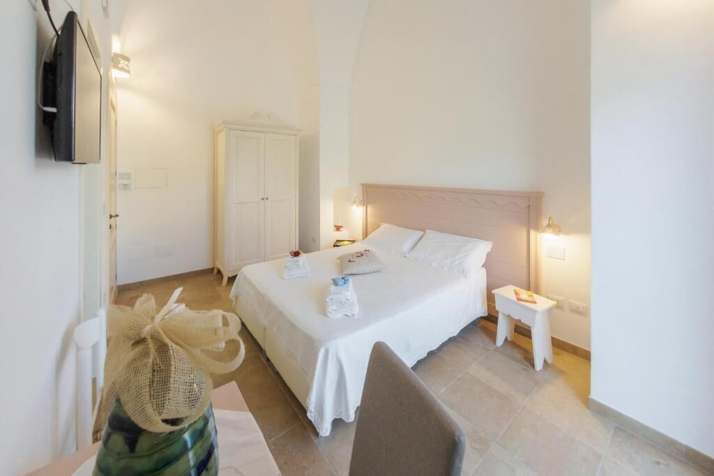 Een hotelkamer met een bed, nachtkastjes, een televisie en een kledingkast.