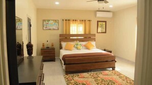 A bedroom with a wooden bed, a nightstand, a ceiling fan, and a patterned rug.