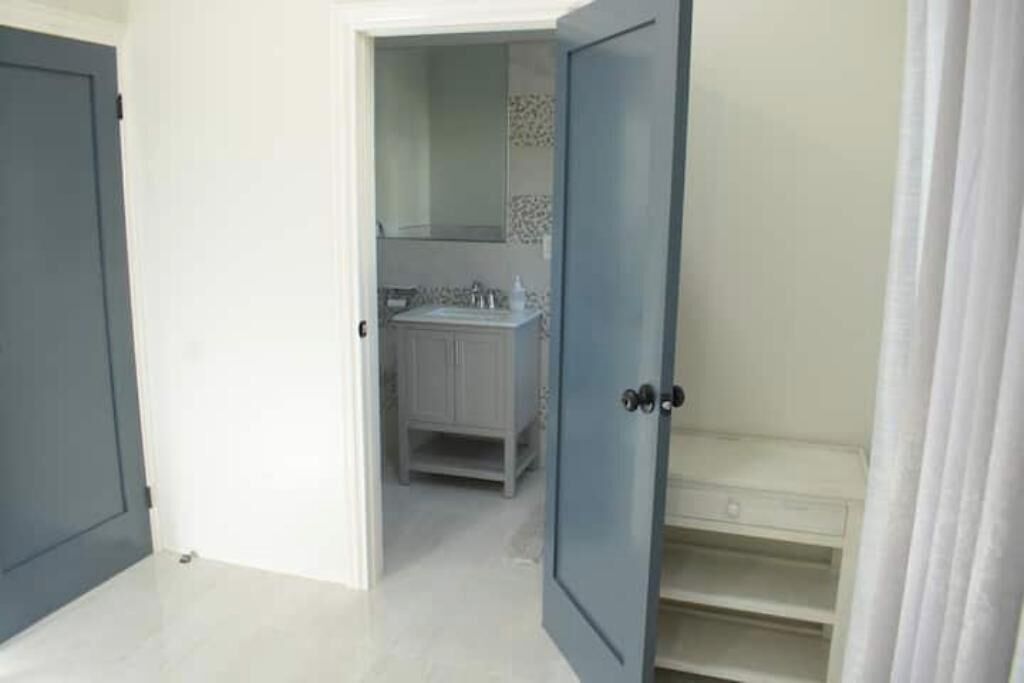 A bathroom with a white sink, mirror, and tiled backsplash.
