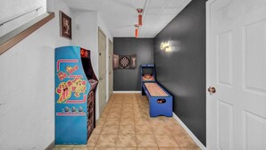 A hallway with a dartboard, a pinball machine, and a ping pong table. - Fun 3 BR Home in Ohio City | Game Room | Sleeps 11 (Cleveland)