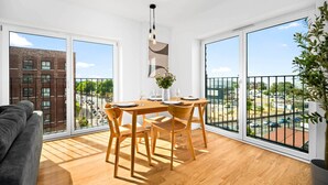 Un appartamento moderno con zona pranzo, ampie finestre e un balcone.