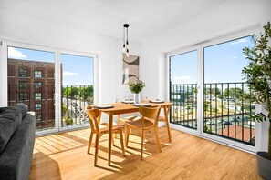 A modern apartment with a dining area, large windows, and a balcony. - Luxury 2 Bedroom - Juliette Balcony - Fast Wi-Fi - Netflix (Birmingham)