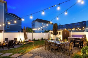 An outdoor patio with string lights, a barbecue grill, and a dining table with chairs. - Luxe & Cozy Gem: Walk to Beach & Boardwalk - Bikes (Atlantic City)