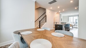 Un área de comedor moderna con una mesa de madera y sillas tapizadas en azul claro.