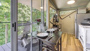 Eine Küche mit Essplatz, einem Kühlschrank und Blick ins Freie.