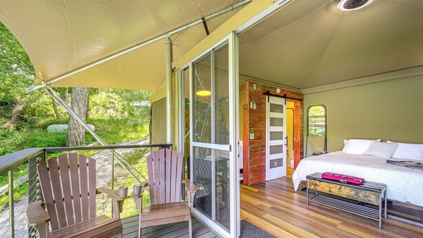 Ein Schlafzimmer mit einem Bett, einem Holzstuhl und einer Sitzbank.