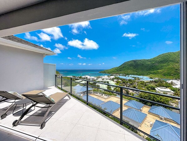 A balcony with a view of a coastal area, including houses and a beach.