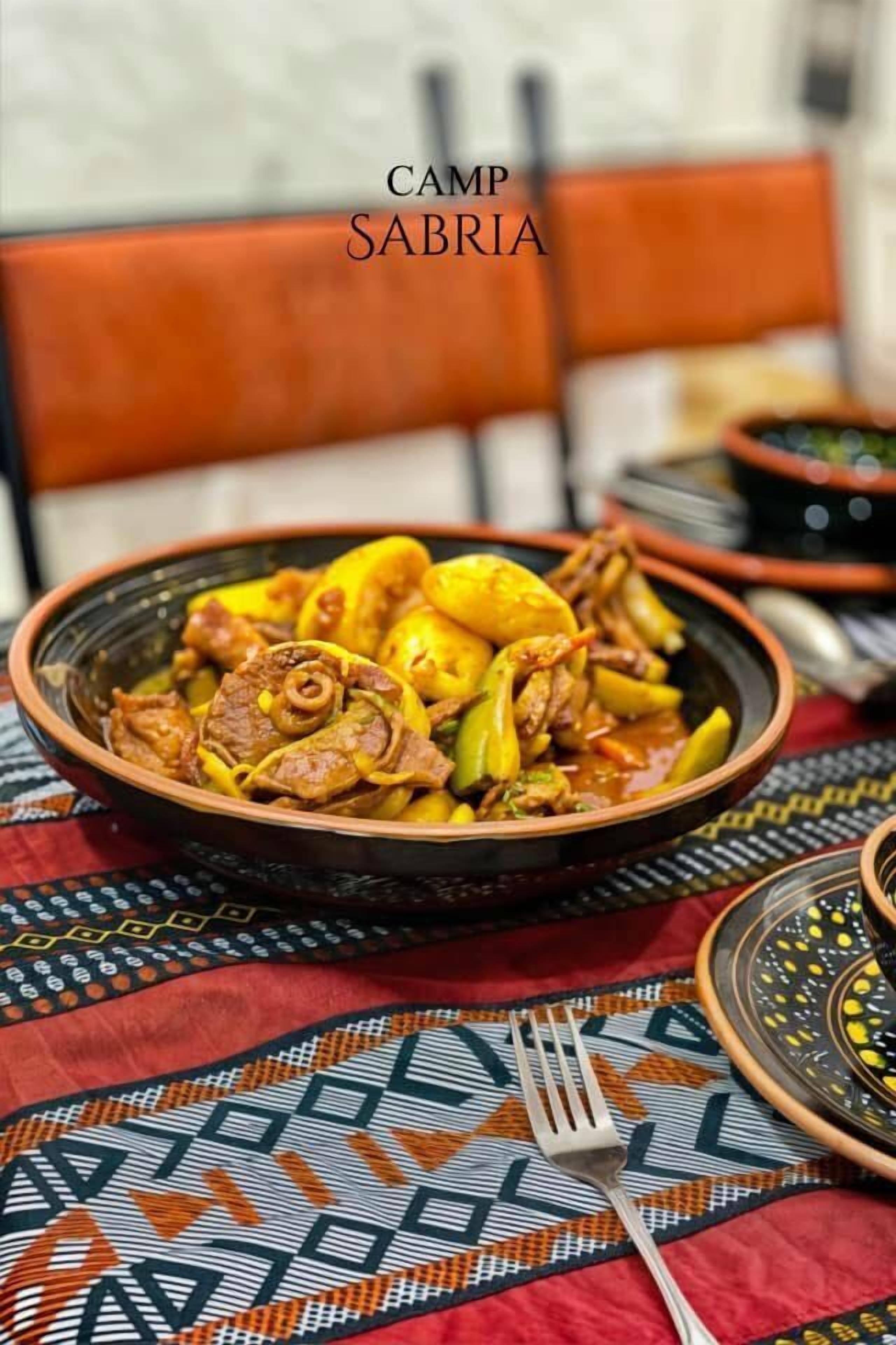 A traditional Moroccan dish, likely a tagine, served in a clay bowl on a patterned tablecloth.