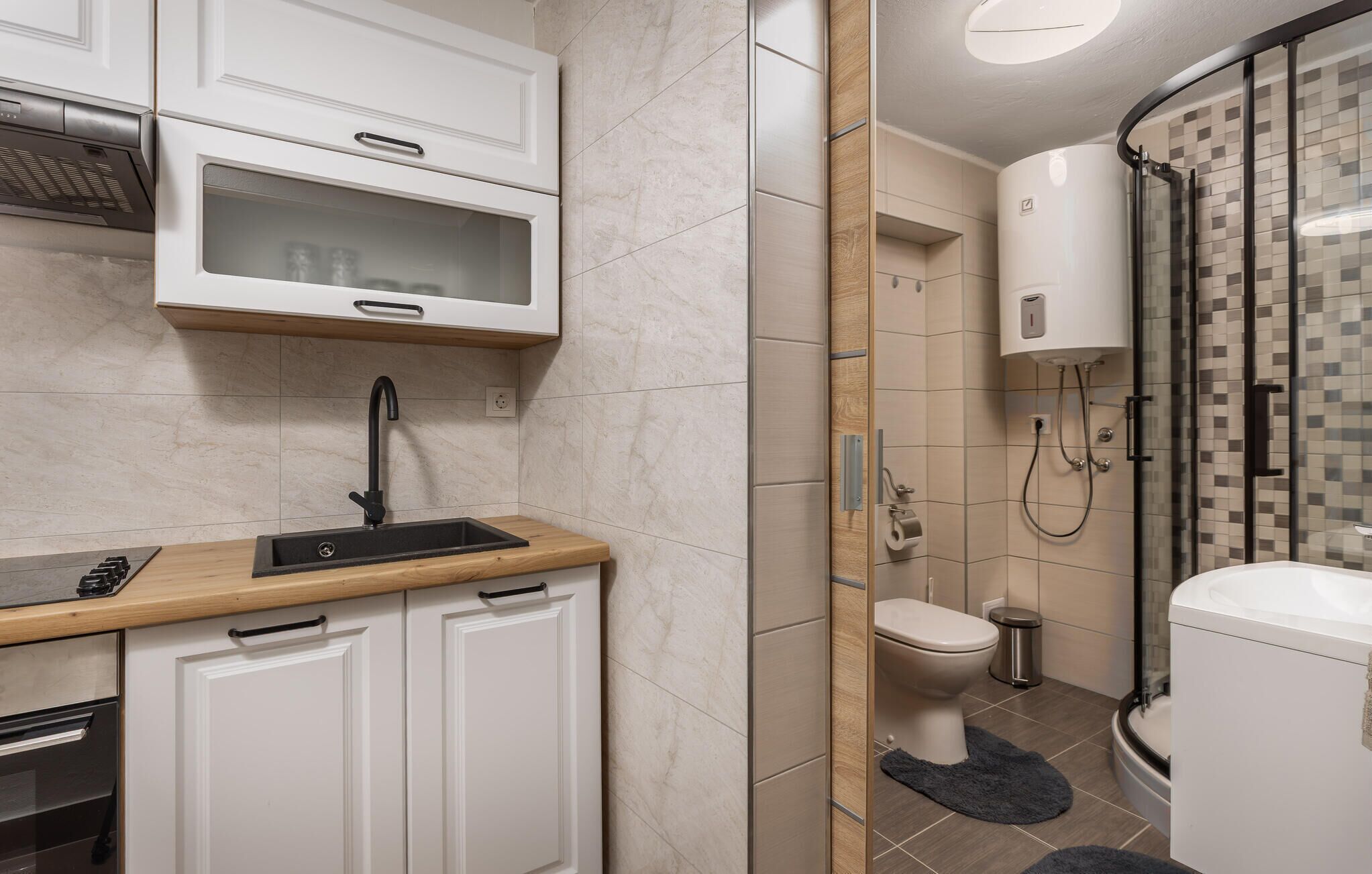 Een moderne badkamer met douche, toilet en wastafel.