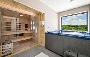 A sauna room with wooden benches, a glass-enclosed shower area, and a large window offering a view of greenery. - Beautiful home in Maglenca with sauna (Maglenca)